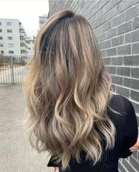 Håret til dame med balayage fra mørkebrunt til blondt. 